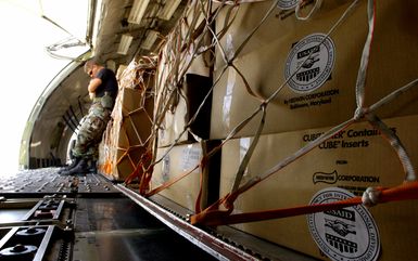 U.S. Air Force AIRMAN 1ST Class Daniel (left) and SENIOR AIRMAN Joshua Durrer (back), both members of the 734th Air Mobility Squadron, Anderson Air Force Base, Guam, rest while they off load pallets of hygiene kits from a DC-8 aircraft from Miami, Fla., during Operation Unified Assistance at Utapoa, Thailand, on Jan. 9, 2005. More than 18,000 U.S. military personnel are providing humanitarian assistance in Southwest Asia after a 9.0 magnitude earthquake on Dec. 26, 2004, triggered devastating tsunamis that killed over 250,000 people in the region. (USAF PHOTO by STAFF SGT. Sarayuth Pinthong) (Released)