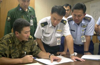 Lieutenant Colonel J. Batsukh, (left), Foreign Relations Officer, Mongolia, explains his plan for deployment of the C-130 Hercules to Major Francis Ngooi Choong Ngee, (center), Air Operations Department, Singapore and Captain Matyussof bin Matyassin, Training no. 4 Squadron, Brunei, at the PACIFIC AIRLIFT RALLY 2001. PACIFIC AIRLIFT RALLY (PAR) is a PACAF-sponsored military airlift symposium for countries in the pacific region. PAR is held every two years and is hosted by a pacific nation. This year Andersen AFB, Guam is the host nation. The symposium includes informational seminars with area of expertise briefings, a command post exercise (CPX) which addresses military airlift support...