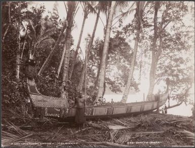 A man standing in front of a painted canoe at Heuru, Solomon Islands, 1906 / J.W. Beattie