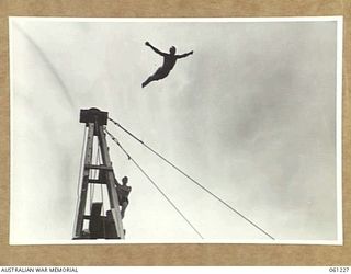 PORT MORESBY, NEW GUINEA. 1943-11-28. LEADING SEAMAN SCOTT, ROYAL AUSTRALIAN NAVY, TAKES OFF FROM THE HIGH DIVING TOWER AT THE ALLIED SERVICES GRAND SWIMMING CARNIVAL