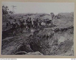 CAPE WOM, WEWAK AREA, NEW GUINEA. 1945-05-06. A LONG LINE OF 2/11 INFANTRY BATTALION TROOPS IN BATTLE ORDER, MOVING OVER A RISE DURING MOVEMENT TO NEW POSITIONS IN PREPARATION FOR THE ADVANCE AND ..