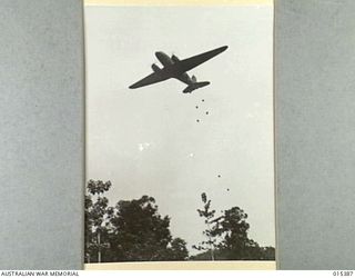 1943-08-03. NEW GUINEA. FOOD AND AMMUNITION FOR ALLIED TROOPS IN THE FORWARD AREA AT MUBO BEING DROPPED FROM A TRANSPORT PLANE. THE CONTAINERS ARE ATTACHED TO PARACHUTES. (NEGATIVE BY G. SHORT)