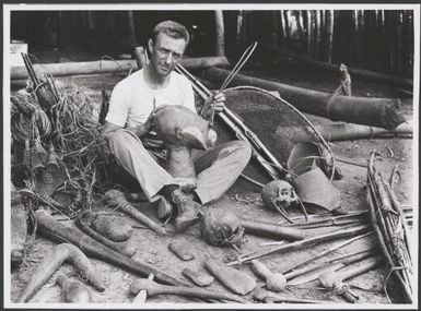 Allan Riverstone McCulloch surrounded by souvenirs, Papua New Guinea, 1922 / Frank Hurley