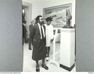 AUSTRALIAN WAR MEMORIAL, CANBERRA, ACT 1976-03-04. MR MICHAEL SOMARE, PRIME MINISTER OF PAPUA NEW GUINEA, LOOKING AT THE SCULPTURE IN BRONZE, FIGHTER PILOT BY R.B. EWERS, ON THE OCCASION OF HIS ..