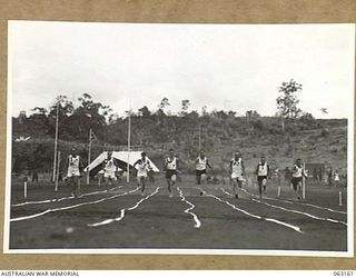 DONADABU, PAPUA, NEW GUINEA. 1944-01-01. THE FINAL OF THE 100 YARDS SPRINT CHAMPIONSHIP IN PROGRESS AT THE 15TH INFANTRY BRIGADE GYMKHANA. IDENTIFIED PERSONNEL ARE: CORPORAL W. WYLLIE (1); CORPORAL ..