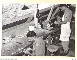LAE AREA, NEW GUINEA. 1945-05-25. MECHANICS WORKING IN THE WORK ROOM AT 54 DENTAL UNIT. THE PHOTOGRAPH INDICATES LIGHTING SYSTEM AND VENTILATION. AN UNIDENTIFIED WARRANT OFFICER IS IN THE ..