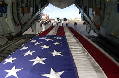 During a commemorative ceremony at Hickam Air Force Base (AFB) Hangar 35, inside a US Air Force (USAF) C-17A Globemaster III, members of a joint honor guard prepare to carry the remains believed to be of unaccounted-for Americans, recovered in Vietnam and Papua New Guinea. The remains will be taken to the Joint POW/MIA Accounting Command's Central Identification Laboratory (JPAC CIL) where they will attempt to positively identify the remains so they can be returned to their families