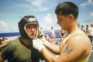 A crew member prepares for a boxing match aboard the battleship USS MISSOURI (BB 63). The ship is en route to Hawaii prior to a cruise to Australia and around the world