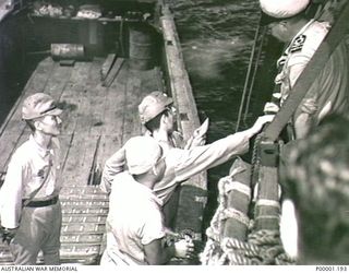 THE SOLOMON ISLANDS, 1945-08-20. JAPANESE BARGE CREW RECEIVING INSTRUCTIONS FROM AN OFFICER ON BOARD HMAS LITHGOW OFF MOILA POINT. THE BARGE HAD DELIVERED TWO JAPANESE OFFICERS FOR SURRENDER ..