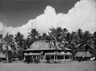 [View of fale, an automobile, and many Palm trees]