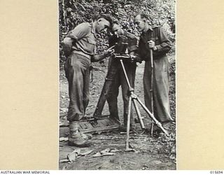 1943-09-14. NEW GUINEA. KOMIATUM RIDGE. AUSTRALIANS EXAMINE A THREE INCH MORTAR CAPTURED FROM THE JAPS AFTER THEY HAD BEEN DRIVEN FROM KOMIATUM RIDGE. THE MORTAR WAS A DUTCH TYPE AND HAD PROBABLY ..