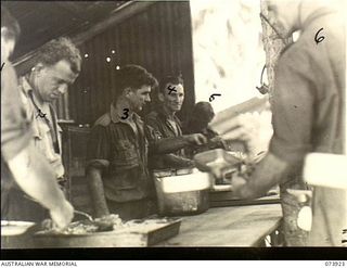 MADANG, NEW GUINEA. 1944-06-17. COOKS AND THEIR ASSISTANTS SERVING LUNCH AT HEADQUARTERS, 15TH INFANTRY BRIGADE. THE UNIT IS LOCATED AT SIAR PLANTATION. LEFT TO RIGHT: VX135531 PRIVATE O. G. ..