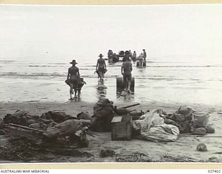 WANIGELA, NEW GUINEA. 1942-10. LOADING STORES OF 2/4TH FIELD COMPANY, ROYAL AUSTRALIAN ENGINEERS, ON TO A LARGE NATIVE CANOE AT WANIGELA MISSION, COLLINGWOOD BAY