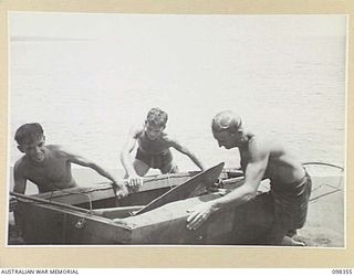 WEWAK, NEW GUINEA. 1945-10-28. SERGEANT R.C. GRAHAM (1); SERGEANT C.J. STRUDWICK (2); AND WARRANT OFFICER 2 R.G. BLYTH (3), MEMBERS OF 16 INFANTRY BRIGADE, HAULING THEIR ENTRY IN THE WEWAK REGATTA ..