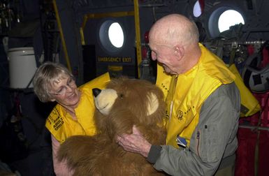 On board a US Air Force (USAF) C-130 Hercules from Yokota Air Base (AB), Japan, retired USAF Colonel (COL) Gail Halvorsen, the Candy Bomber and his wife Lorraine inspect a stuffed bear to be dropped during the first flight of the 50th anniversary flights called the Christmas Drop on Dec. 21 2002