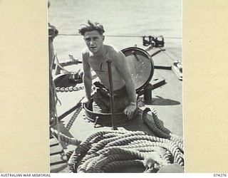 AT SEA. 1944-06-24. STOKER J. YATES, ROYAL AUSTRALIAN NAVY, COMING UP THROUGH THE FOREDECK HATCH ABOARD THE FAIRMILE ML431 (MOTOR LAUNCH) AS THE VESSEL PATROLS ALONG THE COAST BETWEEN HANSA BAY AND ..