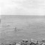 Child on vaka ama (raft) in lagoon