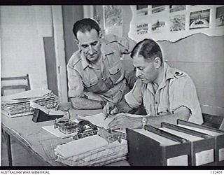 CAIRO, EGYPT. 1945-07. SITTING IN THEIR OFFICE TO THE AUSTRALIAN WAR GRAVES SERVICES, HEADQUARTERS BUILDING AT ABBASIEH ARE VX127936 WARRANT OFFICER R. M. MANGELS (LEFT) AND VX132695 MAJOR R. G. ..