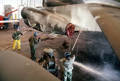 Left to right: SENIOR AIRMAN Richard Griffin, SGT. Alexander Muniz and AIRMAN 1ST Class George Walker, members of the 43rd Bombardment Wing Corrosion Control Branch, scrub down a B-52G aircraft