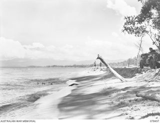 MOTUPINA POINT AREA, BOUGAINVILLE ISLAND. 1945-01-20. LOOKING NORTH ALONG THE BEACH FROM THE POSITION OCCUPIED BY NO.5 BATTERY, 2ND FIELD REGIMENT. IN THE BACKGROUND CAN BE SEEN THE ACTIVE VOLCANO, ..