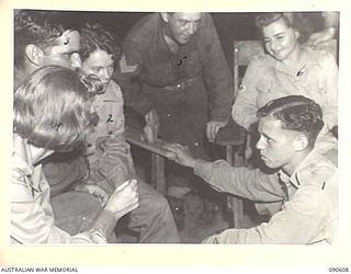 TOROKINA, BOUGAINVILLE. 1945-04-12/13. FORTY-FIVE MEMBERS OF 7 FIELD AMBULANCE STAGED A CONCERT FOR THE ENTERTAINMENT OF UNIT PERSONNEL, PATIENTS AND NEARBY UNITS. HERE PRIVATE R. MCDERMANT, ..