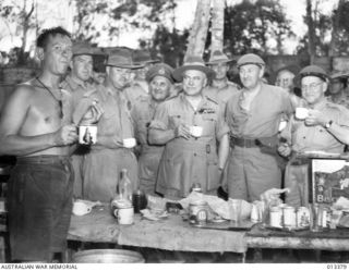 1942-10-08. THE OFFICIAL PARTY HAVE LUNCH WITH TROOPS AT A FORWARD POST. TO THE LEFT AND SLIGHTLY BEHIND GENERAL BLAMEY IS MAJOR-GENERAL ALLEN TO THE RIGHT OF GENERAL BLAMEY ARE MR COLES M.H.R. AND ..