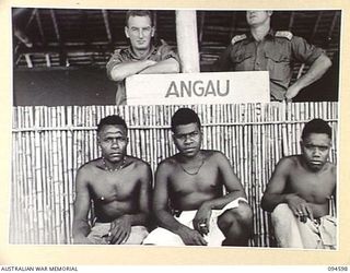 SIPILANGAN, NEW BRITAIN, 1945-07-27. LIEUTENANT J.G. KINSEY, COMMANDING OFFICER AUSTRALIAN NEW GUINEA ADMINISTRATIVE UNIT REFUGEE CAMP (1), AND WARRANT OFFICER 2 T. PALFRAMAN (2), WITH MEMBERS OF ..