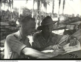 LOS NEGROS ISLAND, ADMIRALTY ISLANDS. 1944-03-18. READING A MAP, FLYING OFFICER (FO) GEOFF MITTON OF SHEPPARTON, VIC (LEFT), AND FO F. O'KEEFE, NSW, MEMBERS OF THE FIRST LARGE PARTY OF RAAF TO GO ..