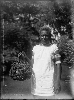 Kavieng woman with a cuscus in a cage in Chinnery's garden, Malaguna Road, Rabaul, New Guinea, 1929 / Sarah Chinnery