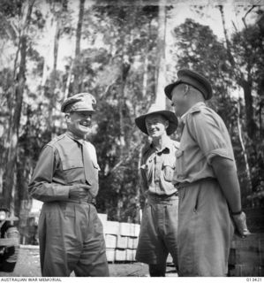 General MacArthur in light-hearted mood during a talk with Australian officers at the foot of the Golden Staircase in New Guinea. From left to right: General MacArthur, smiling; Lieutenant Nicholas ..