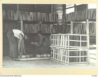 LAE, NEW GUINEA. 1944-03-30. VX25511 PRIVATE S. MCINTOSH (LEFT), WITH VX122495 PRIVATE G. A. SHARP (RIGHT), STACKING BREAD AT THE 8TH FIELD BAKING PLATOON FOR FUTURE ISSUE TO ARMY PERSONNEL