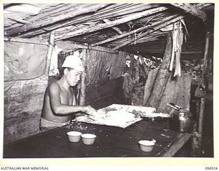 KAHILI, BOUGAINVILLE. 1945-09-10. A MEMBER OF THE JAPANESE FORCES PREPARING TAPIOCA PATTIES IN A HUT AT THE JAPANESE CAMP. THE BUIN LIAISON PARTY FROM HEADQUARTERS 2 CORPS IS ORGANISING SURRENDER ..