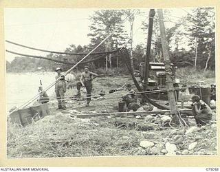 LAE, NEW GUINEA. 1944-08-08. TROOPS OF THE 20TH FIELD COMPANY, USING A "FLYING FOX" TO TRANSPORT MATERIALS ACROSS THE RIVER DURING THE BUILDING OF A BRIDGE ACROSS THE BUSU RIVER. OVERHEAD CAN BE ..