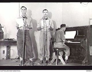 JACQUINOT BAY, NEW BRITAIN. 1945-11-20. THE ARTISTS IN UNIFORM SESSION IN PROGRESS IN THE MAIN STUDIO OF AUSTRALIAN ARMY AMENITIES SERVICE BROADCASTING STATION 9AE