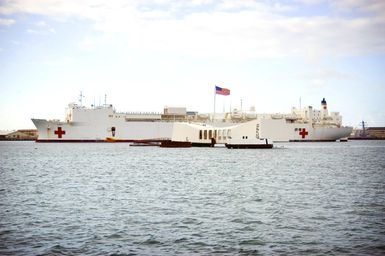 The U.S. Navy Military Sealift Command Mercy Class Hospital Ship USNS MERCY (T-AH 19) sails past the USS ARIZONA Memorial (front) as it enters Naval Station Pearl Harbor, Hawaii, on Sept. 20, 2006, for a brief port visit enroute to its homeport at Naval Base San Diego, Calif. The MERCY, a converted San Clemente Class Super Tanker, is at the end of a five-month humanitarian and civic assistance deployment to Southern and Southeast Asia. (U.S. Navy photo by Mass Communication SPECIALIST 3rd Class Ben A. Gonzales) (Released)