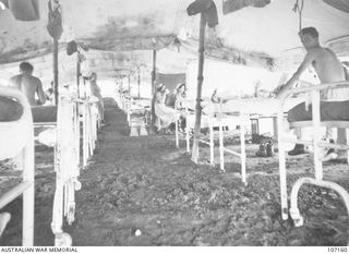 Port Moresby, Papua. 1943. Interior of a tent ward at the 2/9th Australian General Hospital. Nurses stop for a tea break. Note the earth floor