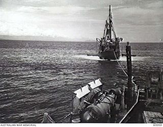 COLLINGWOOD BAY, NEW GUINEA. THE CORVETTE HMAS BROOME PREPARING TO TOW OFF THE GROUNDED MERCHANT VESSEL COORABIE. THE COORABIE HAS HER ENGINES FULL ASTERN AS THE BROOME PREPARES TO TAKE UP THE ..