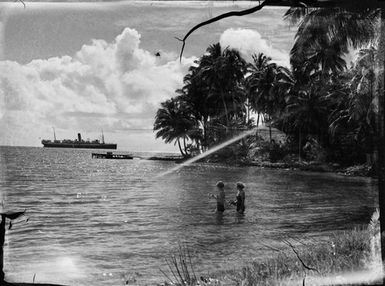 [Two women swimming at a tropical beach]