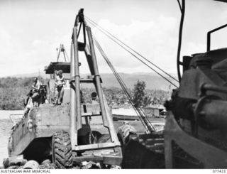 JACQUINOT BAY, NEW BRITAIN. 1944-12-01. A LARGE MOBILE CRANE LIFTING AN LCM (LANDING CRAFT MECHANISED) OUT OF THE WATER FOR OVERHAUL AT THE MAINTENANCE SECTION BEACH-HEAD OF B COMPANY, 594TH ..