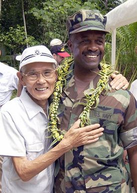 Mr. Kiyokazu Tsuchida (left), a former World War II (WWII) Japanese Army Soldier, and US Navy (USN) Rear Admiral (RADM) Arthur J. Johnson, Commander, US Naval Region Marianas, meet and embrace during a ceremony commemorating the 60th Anniversary of the Battle of Peleliu, held at Peleliu Island, Guam. Mr. Tsuchida, who was stationed on the island in 1944 hid in the Islands cave and jungles for nearly two years after the war ended and did not surrender to American forces until April 1947