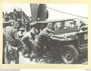 TSIMBA AREA, BOUGAINVILLE ISLAND. 1945-02-16. TROOPS OF THE 4TH FIELD REGIMENT, LANDING THE UNIT JEEPS AND TRUCKS ON THE BEACH AT PUTO