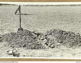 FORBES, NSW. 1943-02. "GUINEA PIGS" TAKING PART IN AN EXPERIMENTAL GAS SHELL SHOOT BY 2/2 FIELD REGIMENT, ROYAL AUSTRALIAN ARTILLERY, REHEARSE THE "TAKE COVER" POSITION IN A TRENCH IN THE CENTRE OF ..