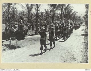 JACQUINOT BAY, NEW BRITAIN. 1945-04-21. BRIGADIER C.R.V. EDGAR, COMMANDER 4 INFANTRY BRIGADE (1), TAKES THE SALUTE FROM A COMPANY, 37/52 INFANTRY BATTALION DURING THE MARCH PAST