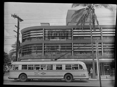 Trolley bus, in front of commercial building, Honolulu, Hawaii