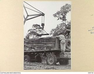 YALU AREA, NEW GUINEA, 1945-07-30. A TC 20 CRANE OPERATED BY NO. 2 PLATOON, 2/1 FORESTRY COMPANY, ROYAL AUSTRALIAN ENGINEERS, LOADING TIMBER ON TO A TRUCK