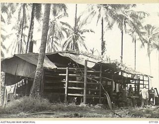 JACQUINOT BAY, NEW BRITAIN. 1944-11-21. THE OLD COPRA DRYING SHED ON THE PALMALMAL PLANTATION, WHICH WAS FORMALLY A JAPANESE KITCHEN, BUT IS NOW BEING USED BY THE 157TH, SUPPLY DEPOT PLATOON