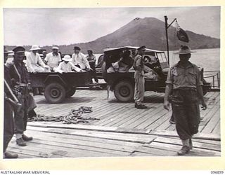 TOBOI WHARF, NEW BRITAIN. 1945-09-16. A PARTY OF MISSIONARY SISTERS AND PRIESTS WHO HAVE BEEN LIBERATED FROM INTERNMENT AT RAMALE MISSION LEAVING THE WHARF AREA BY JEEP FOR 4 FIELD AMBULANCE WHERE ..