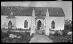 Mauke church with pillars in front, emblems of god