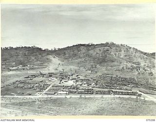 PORT MORESBY, PAPUA, 1944-08-16. A SECTION OF THE ORDNANCE VEHICLE PARK OF THE 10TH ADVANCED ORDNANCE DEPOT SHOWING THE UNIT OFFICE IN THE MIDDLE FOREGROUND SURROUNDED BY ACRES OF PARKED MOTOR ..