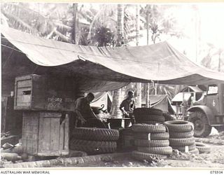 NORTH ALEXISHAFEN, NEW GUINEA. 1944-09-14. NX110641 CORPORAL J. BARNES (1) AND NX110631 PRIVATE A. HUGHES (2) STOREMEN, WORKING IN THE INWARDS AND DESPATCH DUMP OF THE 133RD BRIGADE ORDNANCE FIELD ..